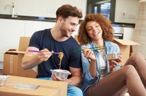 Couple Moving Into New Home Enjoying Takeaway Meal